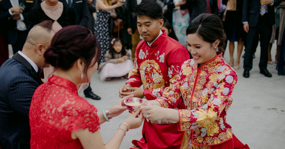 Female hand hold a box wrapped in red paper and tied with a red