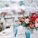 Vintage Blue Glassware and Bright Floral Arrangements on Wedding Reception Tables