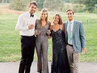 Wedding guests in formal attire posing for group photo