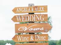 Wood wedding sign pointing to activities for guests