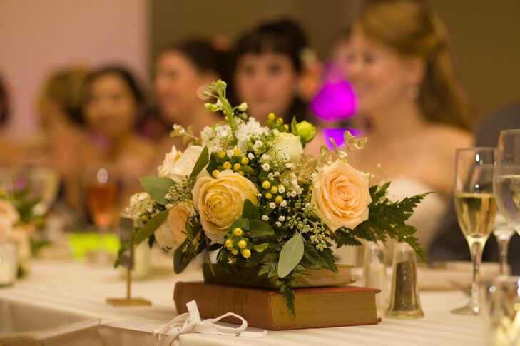 Centerpieces at the reception were made up of roses and hypericum berries on stacks of hardcover books for a vintage touch.