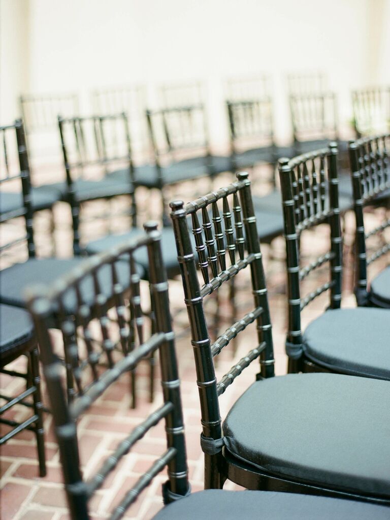 row of black chiavari wedding chairs with black cushions