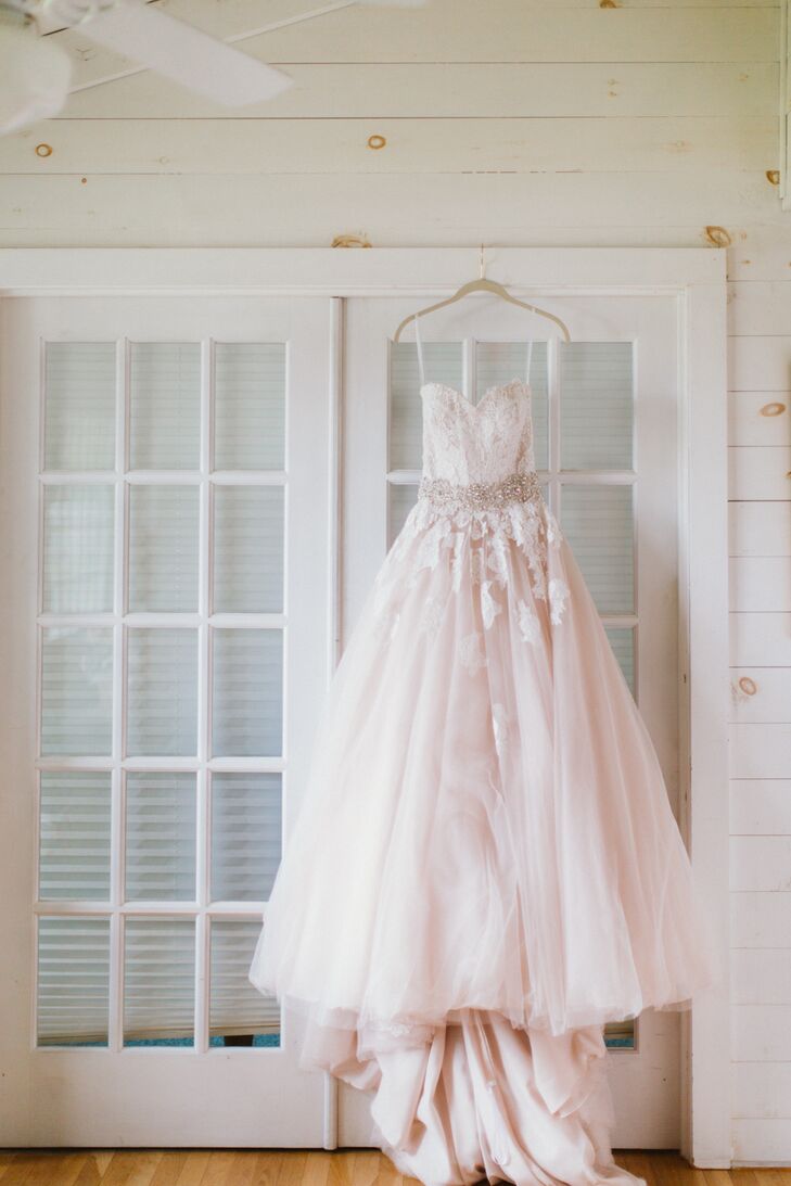 When it came to her bridal look, Katherine knew she wanted to go all out romantic. The bride-to-be was instantly drawn to gowns with a hint of color, ultimately settling on a champagne-blush number by Allure. “The color was unique, the lace bodice was very romantic, but the illusion back gave the gown a bit of sexiness too,” says Katherine. She added a crystal-embellished belt and shimmery silver sandals for a touch of glam and a fingertip-length veil secured with a gilded leaf comb.