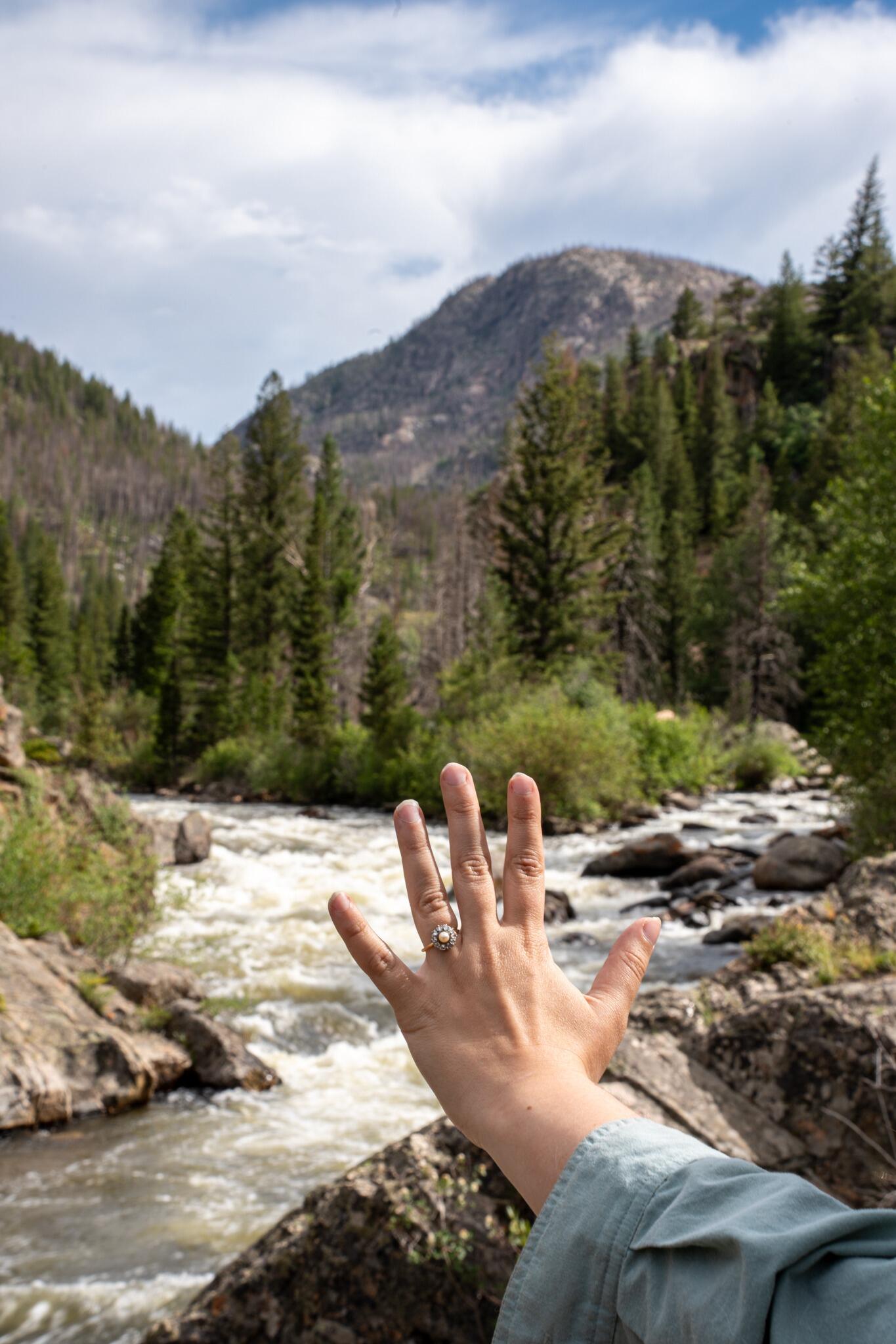 The engagement spot. A mother-son fishing duo had claimed Austin's intended location, forcing a quick pivot to a spot just over some nearby boulders. But it was clearly meant to be—the two rivers coming together in the background created the perfect symbolic backdrop.
