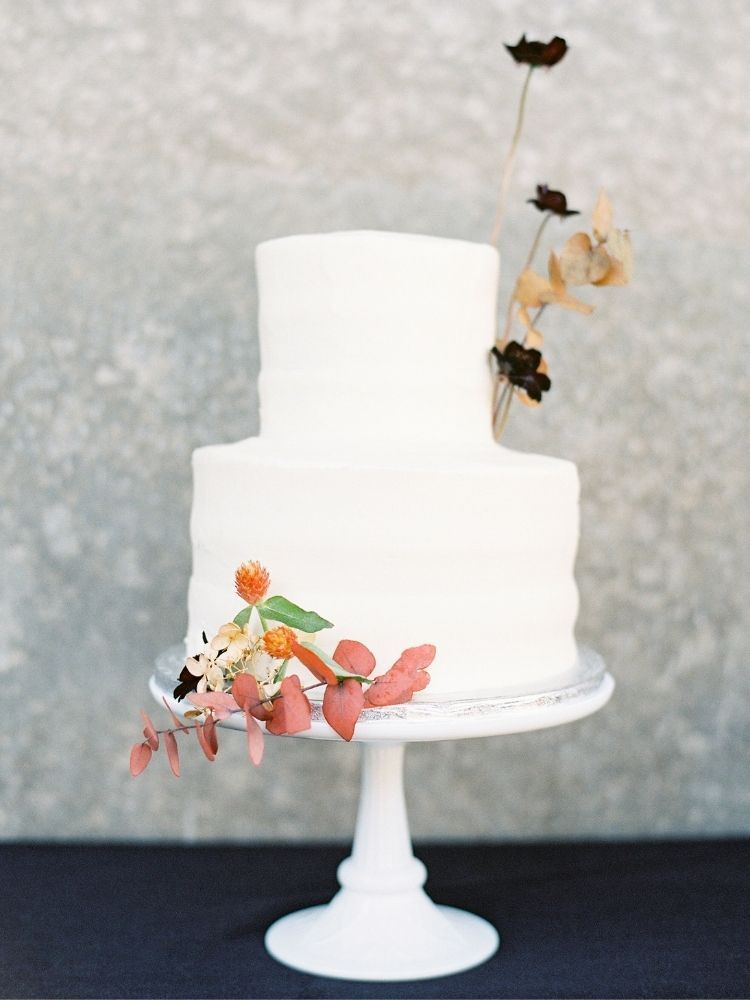 two-tier white cake with fresh cosmo flowers