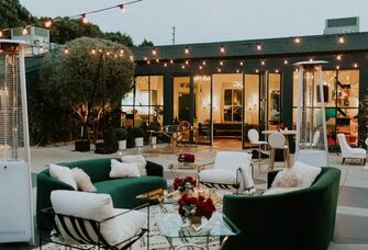 Stunning outdoor event space with comfortable furniture and string lights. 