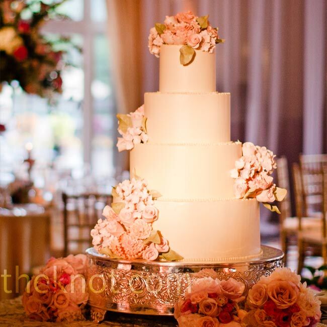Coated in buttercream frosting, the four-tiered cake was decorated with handmade sugar flowers.
