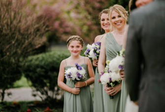 junior maid of honor standing with bridal party at wedding