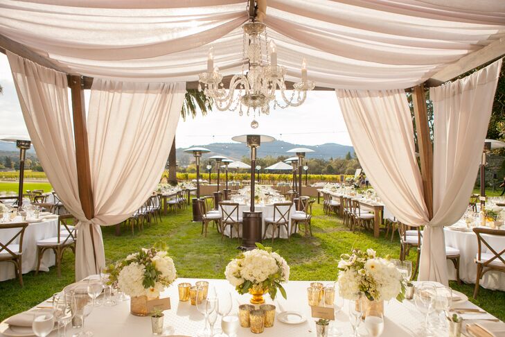 In keeping with the day's chic aesthetic, white linens were used to create cabanas at the outdoor reception at Chateau St. Jean Winery in Kenwood, California. Chandeliers added an extra touch of elegance.