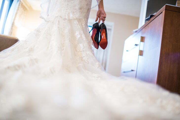 The bride wore a fit and flare gown by Allure Bridals. The fitted bodice had a sweetheart neckline embellished with Swarovski crystals. The entire design was adorned with delicate lace appliqué on English net. She styled it with diamond tear drop earrings black Christian Louboutin heels to incorporate the black tie theme. rn