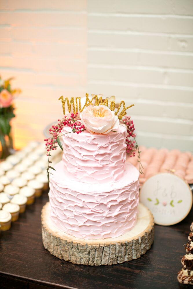 “I loved my wedding cake,” Jessica says. “I knew I wanted to do something different from your traditional wedding cake—why not have fun with it?—and went with a blush pink textured icing, adding garden roses and berries to the top. I bought a topper on Etsy that read 'Mr. and Mrs.' in gold—a perfect touch.”