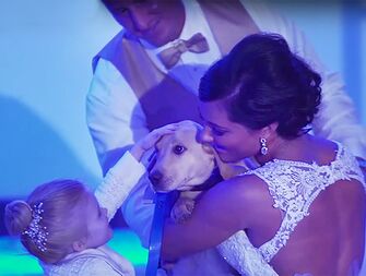 bride, groom and flowergirl with dog