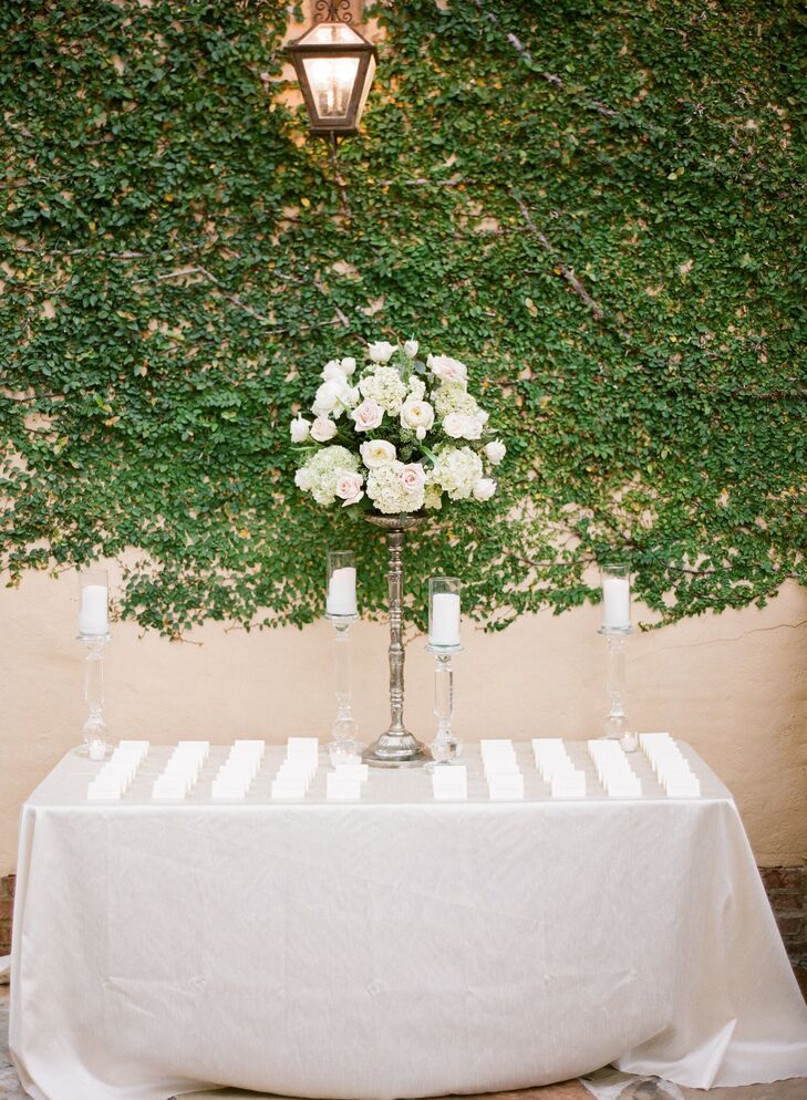 The escort cards were elegantly displayed alongside pillar candles and a pewter candelabra topped with blush and ivory flowers.