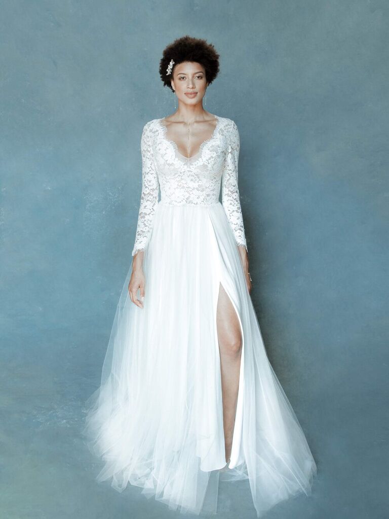 Model wears a long sleeve wedding dress with a lace bodice. 
