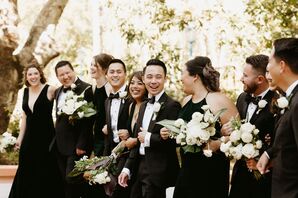 Groom in Classic Black Tuxedo With Mixed-Gender Wedding Party in All Black, White Flowers