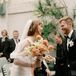 Bride With Light Bouquet of Coral, Blush and White Flowers, Pearl Headband Smiling With Groom in Tux