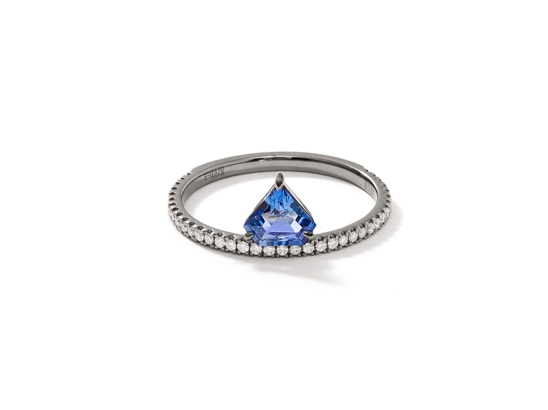 A circular silver band with small diamonds and a triangular-cut sapphire.