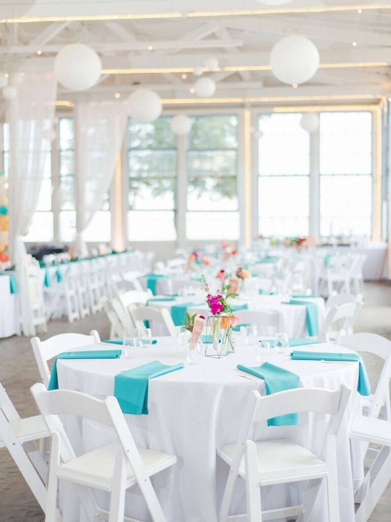 Summer wedding reception with white tables and chairs and teal linens