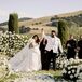 Couple Holding Hands After Outdoor Wedding Ceremony Surrounded by Roses