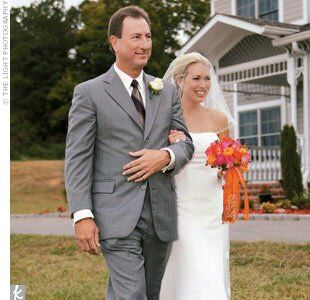 The bride's bouquet, in shades of hot pinks and oranges, was tied with a ribbon embroidered with her monogram.