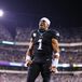 Jalen Hurts celebrates a win in a football stadium surrounded by cheering fans. 