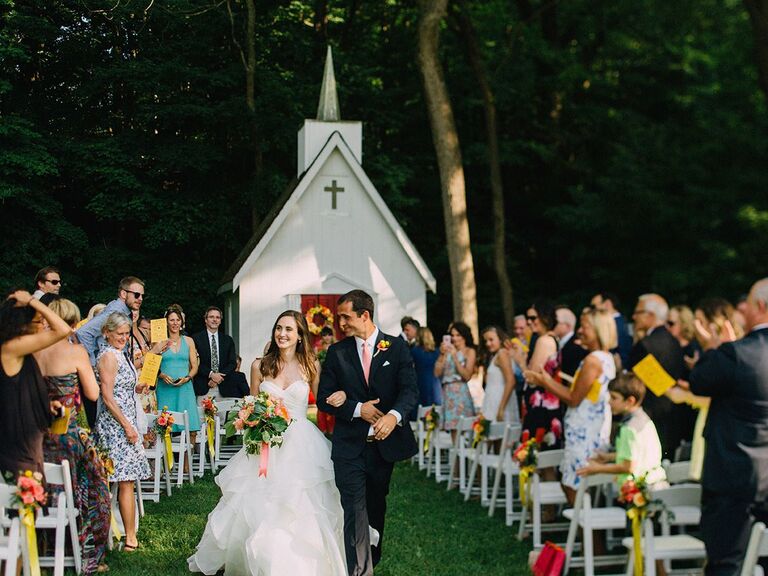 bride and groom walking up the aisle little white chapel outdoors