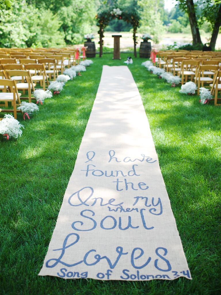 Burlap aisle runner featuring a hand-painted romantic phrase. 