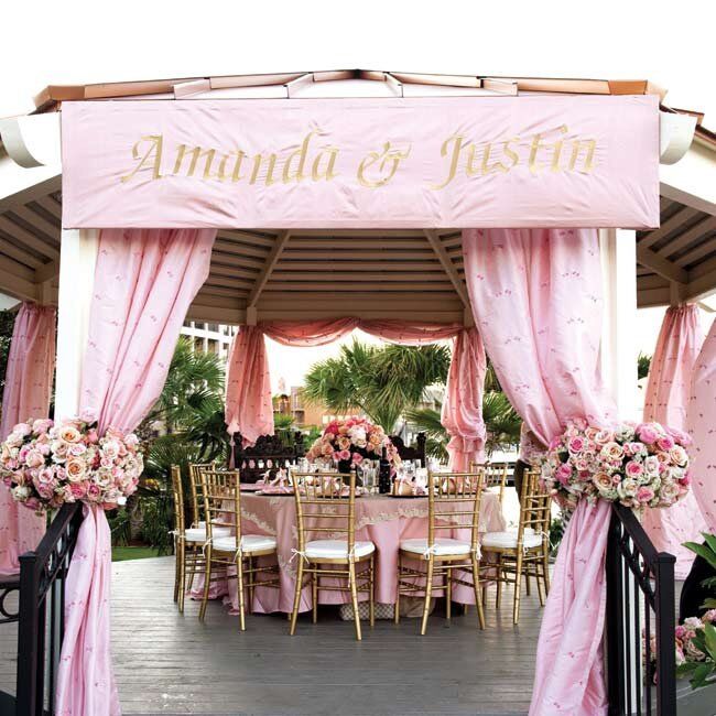 The head table got major VIP treatment: its own gazebo overlooking the lake. Flowy pink draping and a banner with the couple's names finished the look.