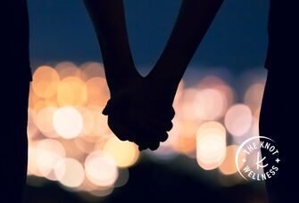 couple holding hands in bright lights