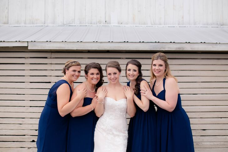 While Emily picked out the navy chiffon, knee-length dresses, her bridesmaids chose the style. They changed things up with personalized necklines ranging from one-shoulder to halter and tied it all together with a string of pearls. Their glam hairstyles by Elite Hair Color and Designs only enhanced the look.
