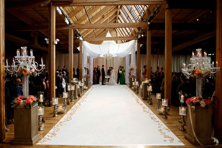 The skyline view and brick and wood surroundings in the Bridgeport Art Center Skyline Loft ceremony location invited guests into the warm, romantic space. Candles and peach, pink and soft green flowers adorned the white linen aisle leading up to a huppah, repurposed from a 1920s parachute.