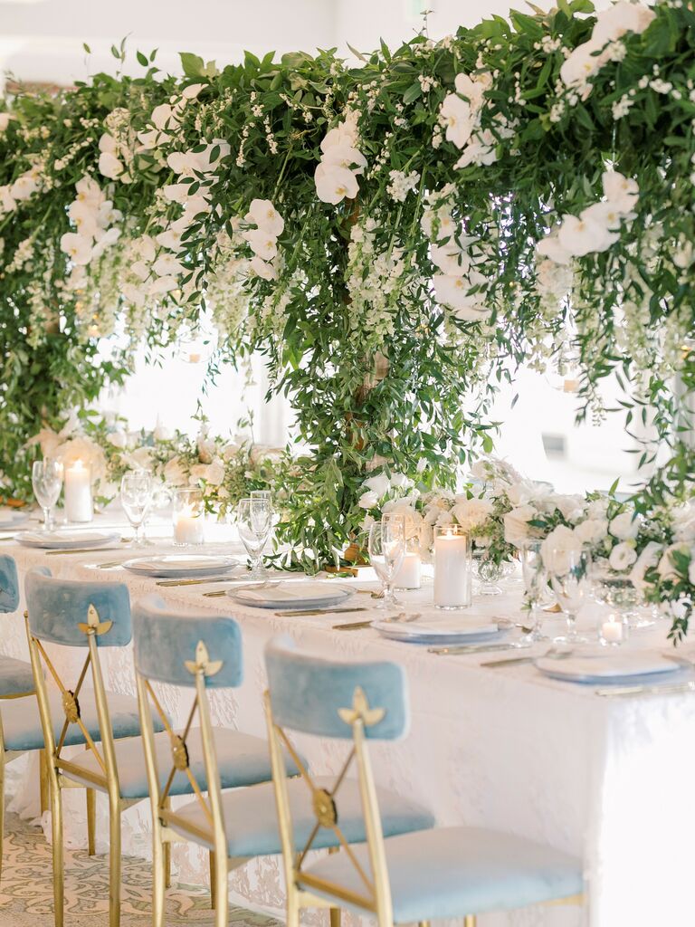 long wedding reception table with tall hanging greenery centerpieces