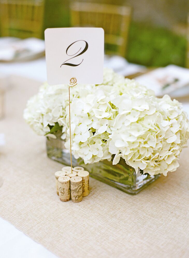 White hydrangeas in rectangular glass boxes made for a refined low centerpiece, while table names were held up with golden rods and placed in a group of wine corks.