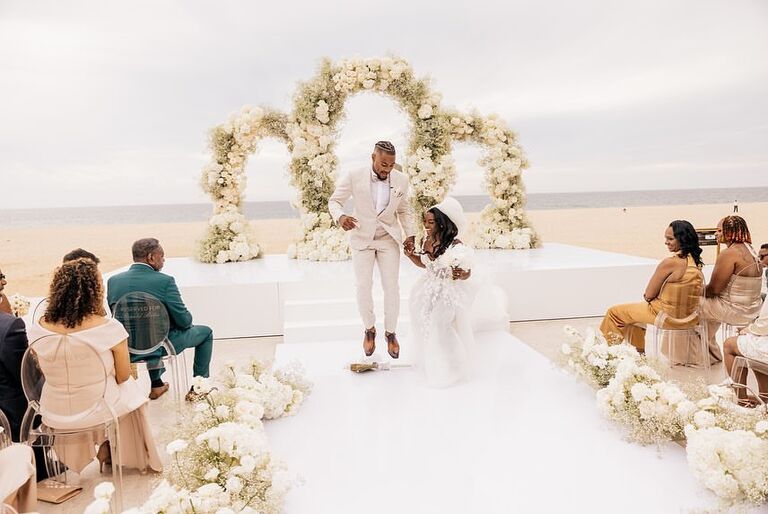 Simone Biles and Jonathan Owens jumping the broom during wedding