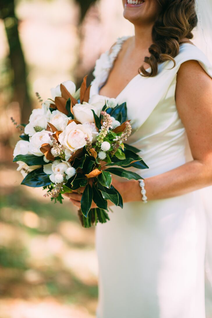 Since Molly's favorite flower, peonies, weren't in season during the time of her wedding, Andrea from LynnVale Studios helped her craft the perfect bouquet. She used ivory and blush roses that resembled peonies and paired them with leaves from Ryan's parents' magnolia tree, since Molly also loves magnolia. She also incorporated small, white dahlias into the bouquet as well as basil leaves, which had the arrangement smelling fresh all day.