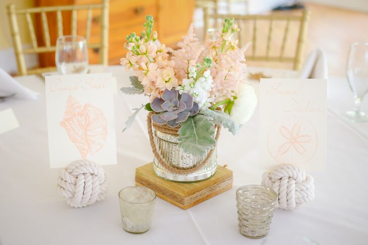 “From the start I had a vision in my head of a whimsical, ethereal and vintage feel mixed with nautical elements,” says Lindsey. Every table was set  to this notion with a low arrangement of succulents, pink and white delphiniums, dusty miller and pink astilbe inside a silver vase wrapped in rope. Wanting to take the nautical theme a step further, they also had table numbers made of knotted rope and chic seashell-inspired table names.