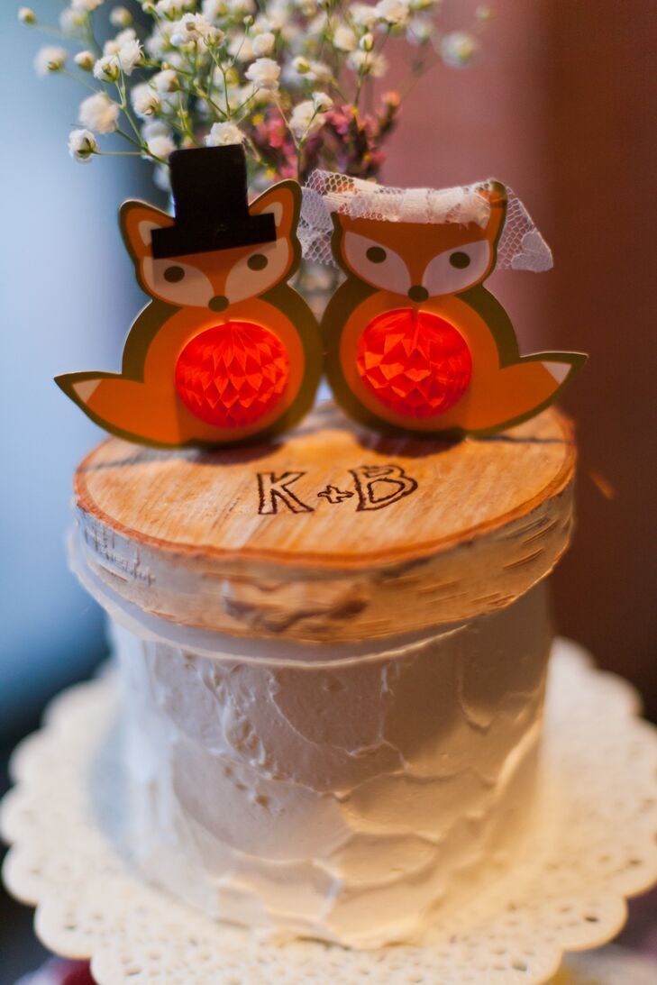 The adorable paper fox cake topper was displayed on top of a small wood slab with Kristen and Blake's initials etched into it. I love foxes, so the topper was a way to personalize the cake a little bit, says Kristen.