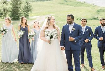 Bride and groom walking in front of wedding party