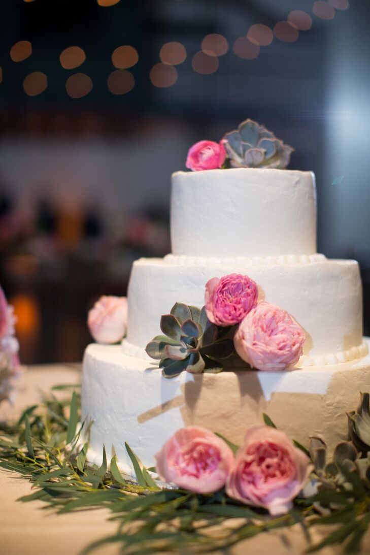 The couple’s three-tier vanilla and caramel-filing wedding cake was topped with succulents and pink blooms.