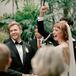 Bride, Groom and Officiant at Altar, Smiling and Laughing Facing Guests During the Ceremony