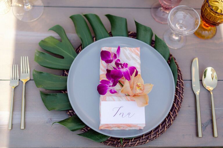 Tropical place setting with monstera leaf charger and orchid accents
