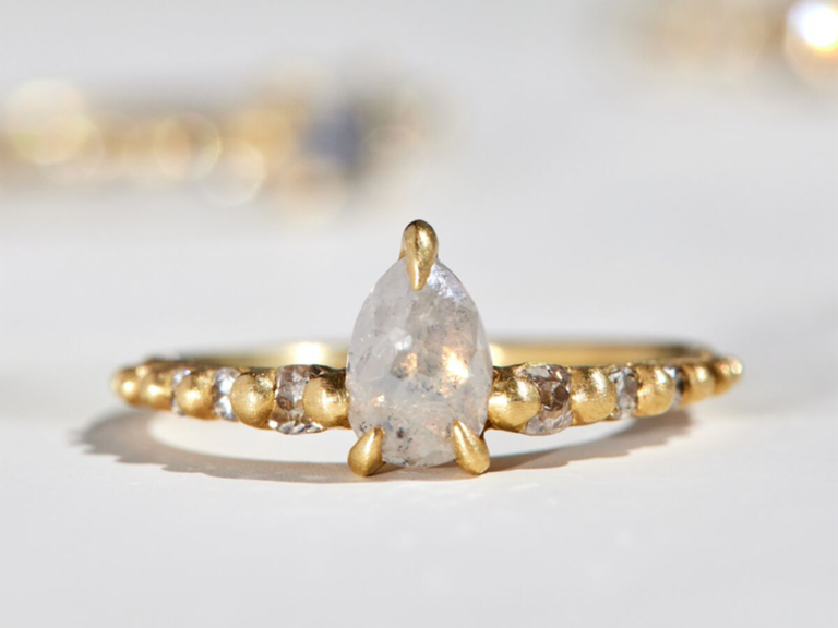 White pear diamond on gold band with diamond side stones