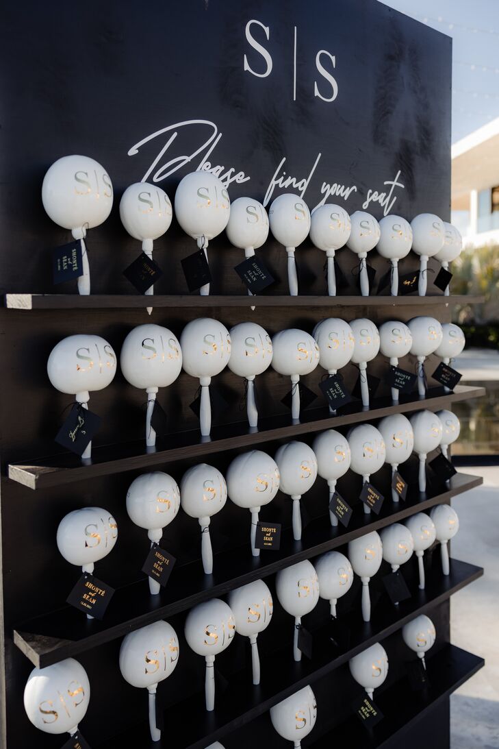 A fun and playful, but sophisticated, escort card display featuring maracas and a black-and-white color palette at a luxury destination wedding in Los Cabo, Mexico.