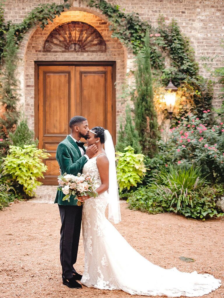 Groom in velvet green tux with bride wearing fit and flare gown with 1920s inspired headband