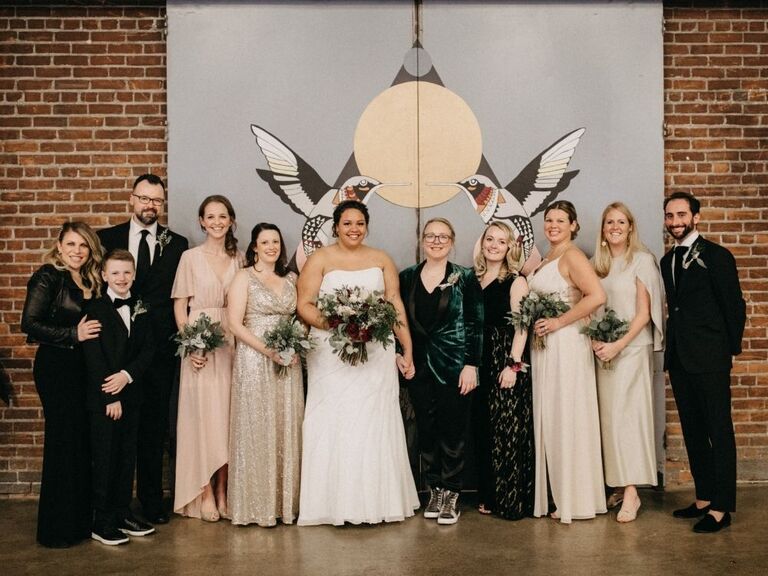 brides posing with wedding party members in industrial loft venue