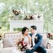 Classic Couple Sitting in Vintage Lounge Area Decorated with Fall Blooms