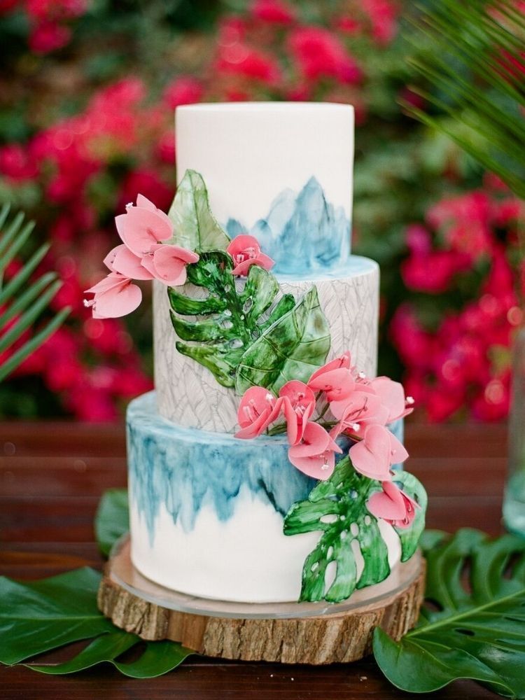 watercolor wedding cake decorated with tropical leaves