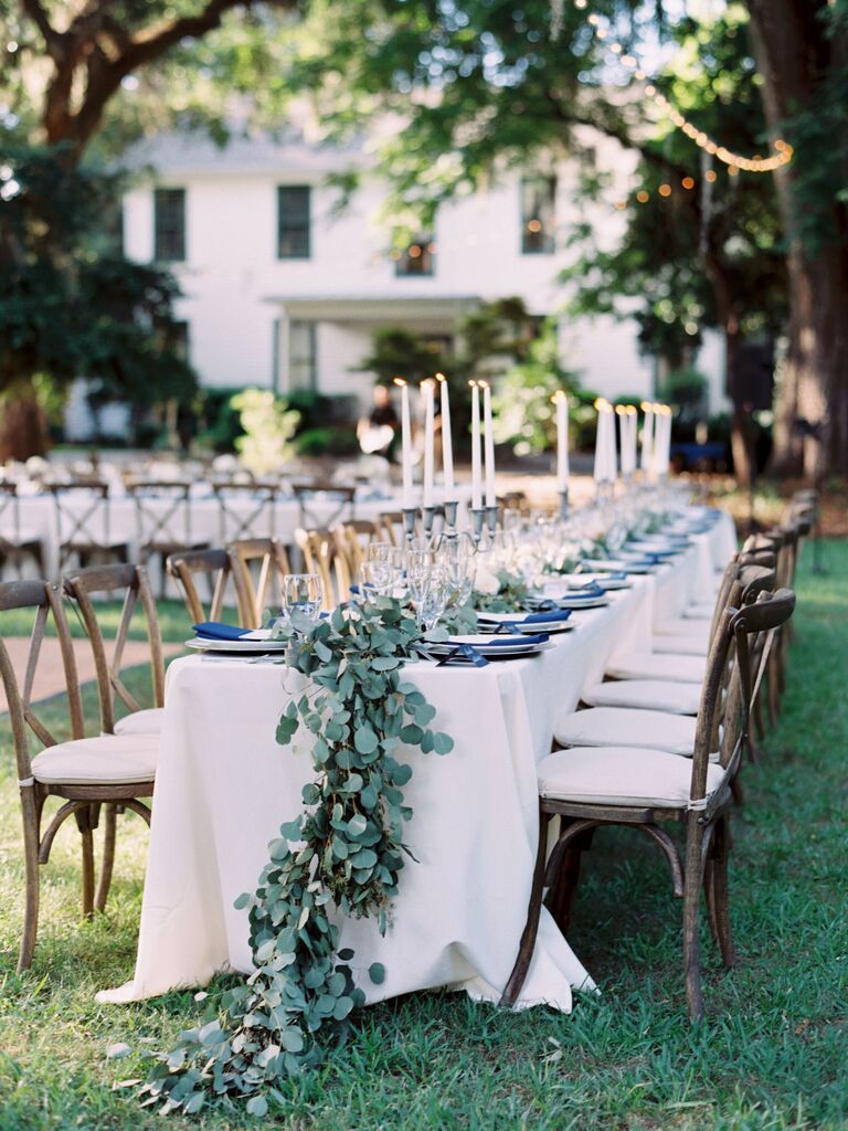 elegant outdoor wedding reception tablescape with eucalyptus runner