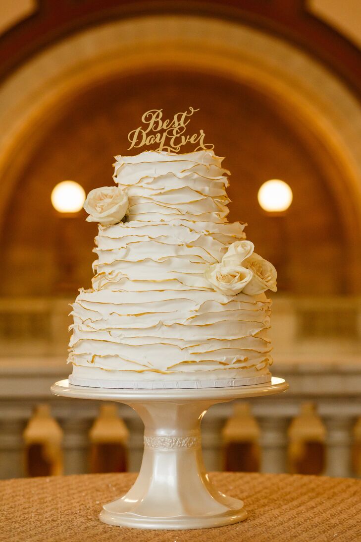 The three-tiered main wedding cake was pumpkin spice with cream cheese frosting. The cake was accented with ivory roses and had a cake topper that read "Best Day Ever."