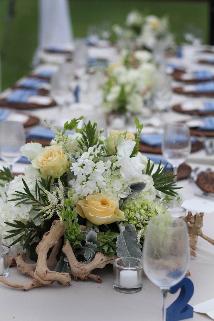 The couple decorated each table with unique centerpieces of curly willow branches, white bottlebrush, grapevine wood, yellow roses, dusty miller and white lisianthus.